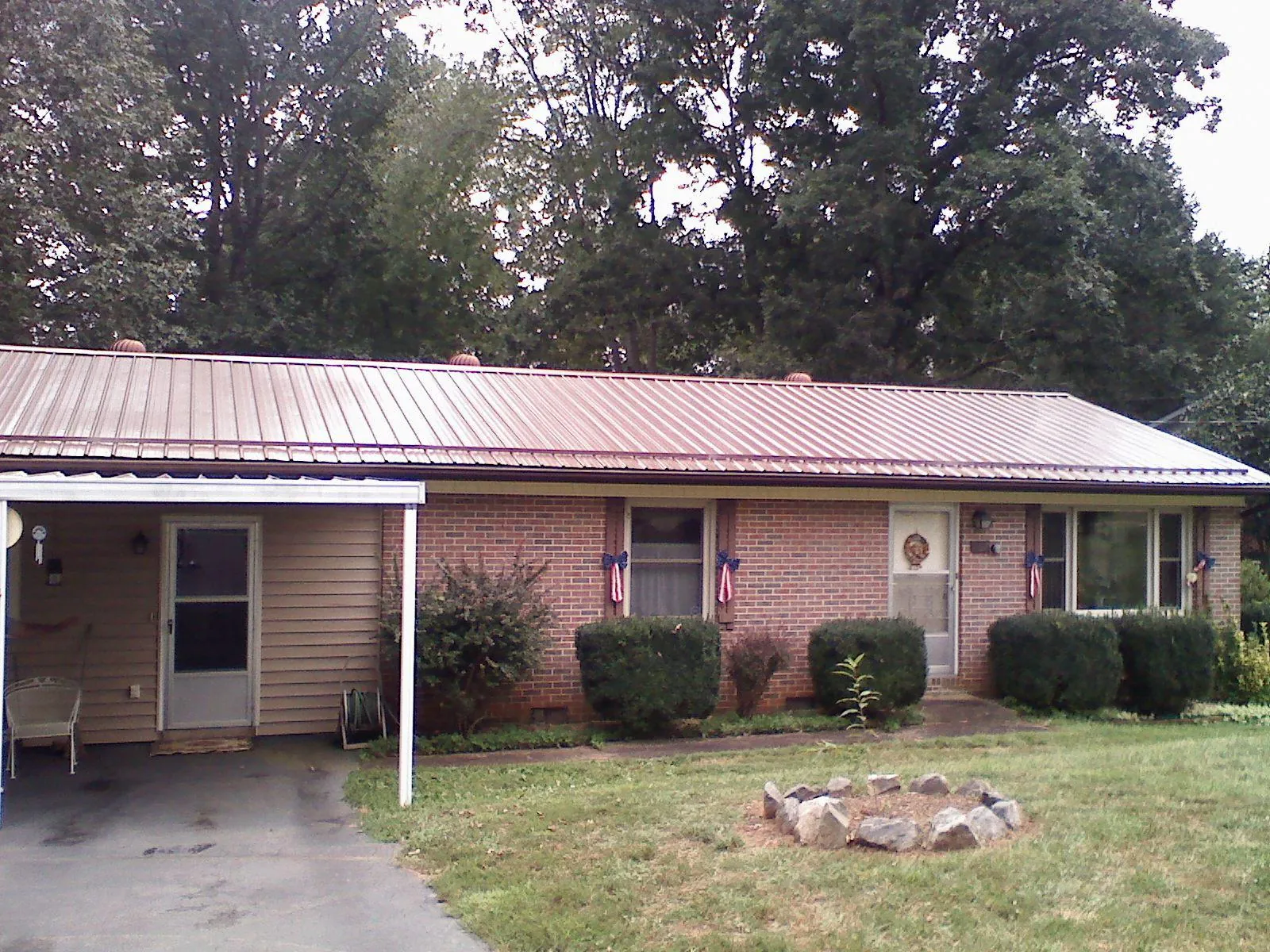 Bronze metal roof and carport on a brick ranch home — Roof Repair work by our crew in Creighton